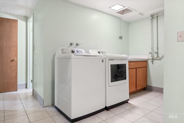 laundry room with washer and dryer and light tile patterned floors