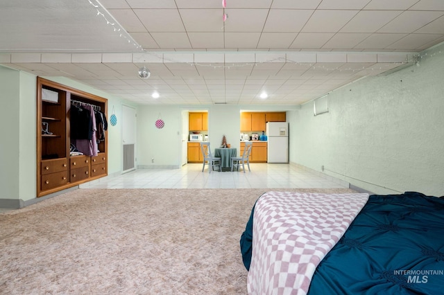 bedroom featuring white refrigerator, light tile patterned floors, and a closet