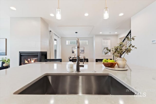 details with recessed lighting, a sink, a fireplace, and hanging light fixtures