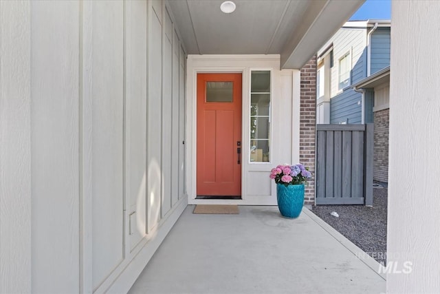 doorway to property featuring board and batten siding and brick siding