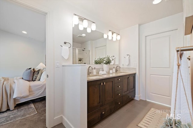 ensuite bathroom with double vanity, a sink, ensuite bath, and a shower stall