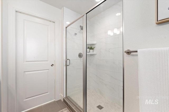 bathroom with tile patterned floors and a shower stall