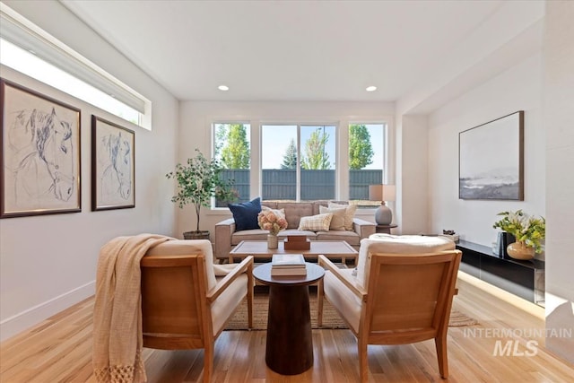 living area featuring recessed lighting, baseboards, and light wood-type flooring