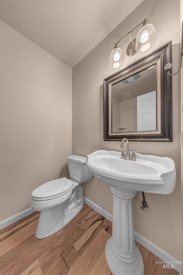 bathroom with wood-type flooring and toilet