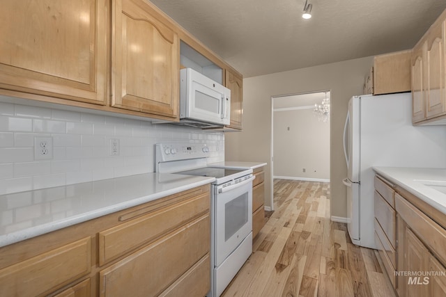 kitchen featuring light brown cabinets, light hardwood / wood-style flooring, a chandelier, white appliances, and decorative backsplash