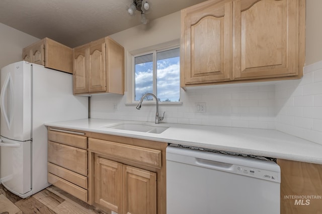 kitchen featuring sink, light brown cabinets, tasteful backsplash, white appliances, and light wood-type flooring