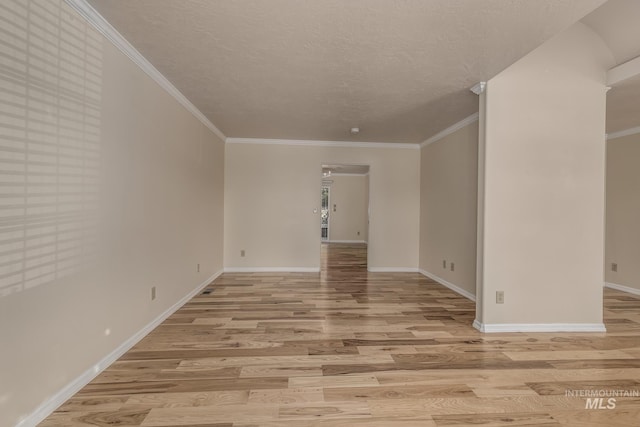 unfurnished room with a textured ceiling, light wood-type flooring, and crown molding