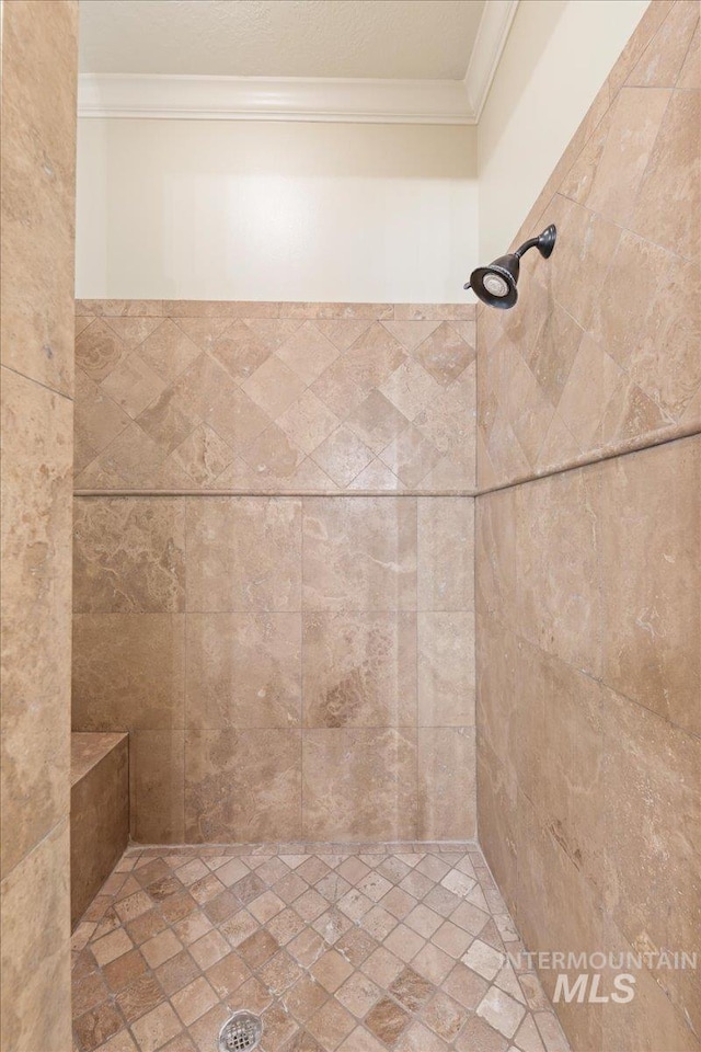 bathroom featuring a tile shower and ornamental molding