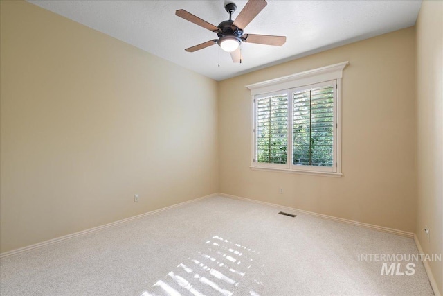 spare room featuring ceiling fan and carpet