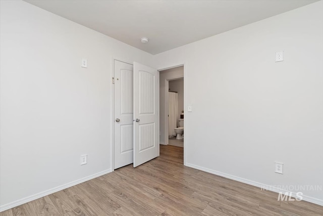 empty room with baseboards and light wood-type flooring