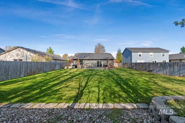 back of property with a fenced backyard and a yard