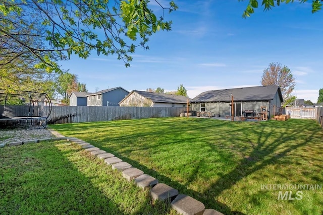 view of yard featuring a fenced backyard, a trampoline, and a patio area