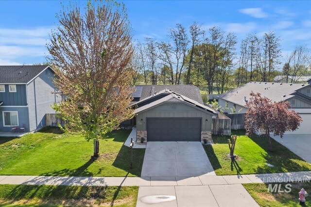 view of front of home featuring an attached garage, fence, driveway, and a front yard