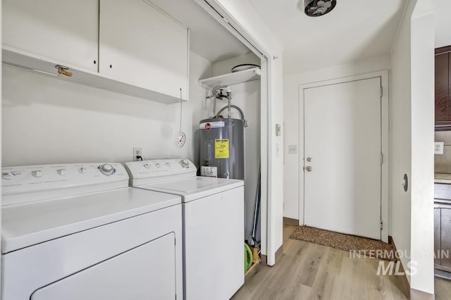 laundry room with washer and dryer, water heater, and light hardwood / wood-style flooring