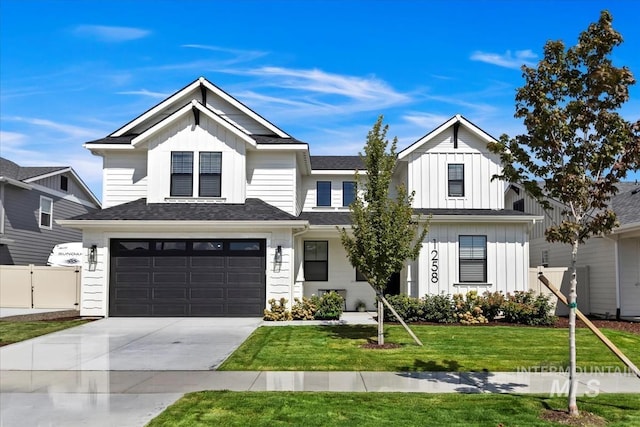 modern inspired farmhouse featuring concrete driveway, board and batten siding, fence, a garage, and a front lawn