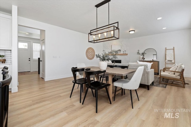 dining space with a notable chandelier, light wood finished floors, recessed lighting, and baseboards