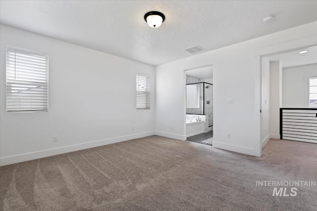 unfurnished bedroom featuring carpet floors, baseboards, visible vents, and ensuite bathroom