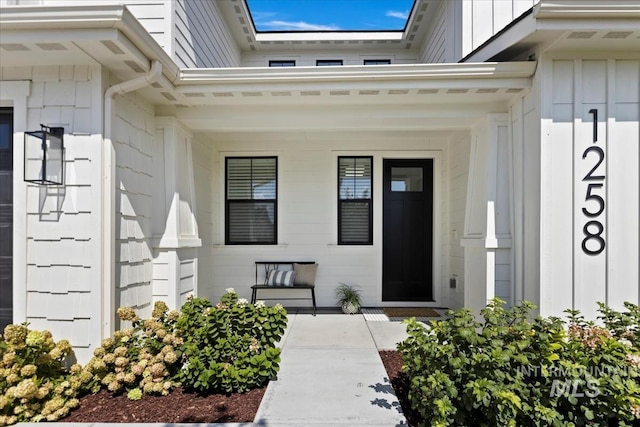 doorway to property featuring a porch and board and batten siding