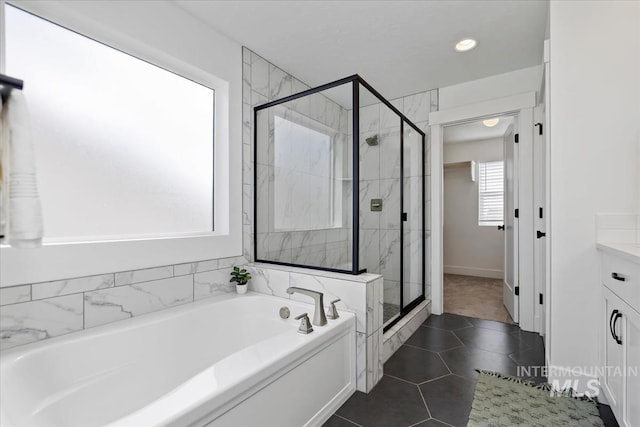 bathroom featuring vanity, a shower stall, a bath, and tile patterned floors