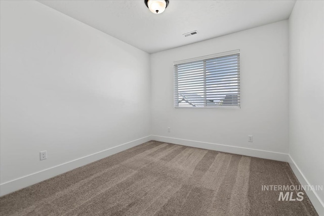 spare room with visible vents, baseboards, and carpet flooring