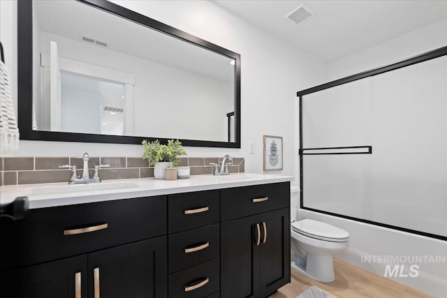 full bathroom with visible vents, double vanity, a sink, and toilet