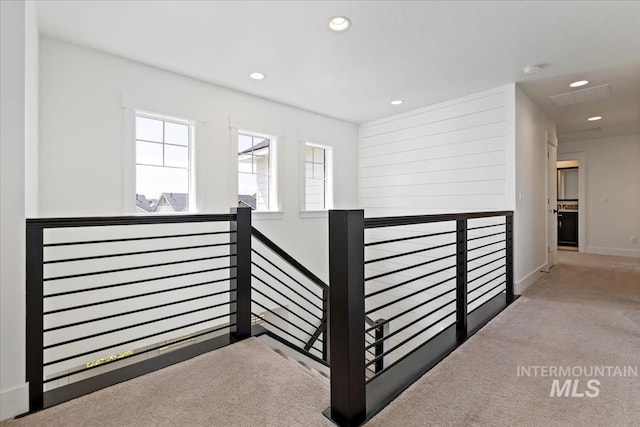 corridor featuring visible vents, baseboards, an upstairs landing, carpet floors, and recessed lighting