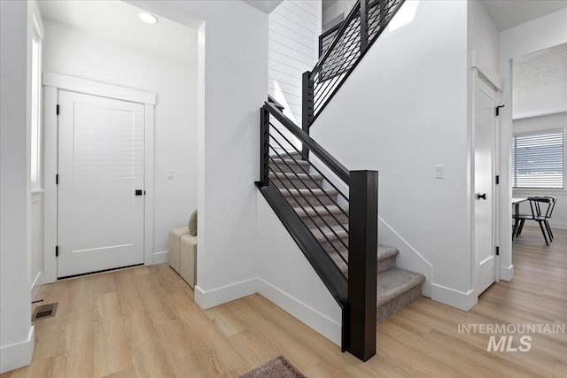 stairs with recessed lighting, wood finished floors, visible vents, and baseboards