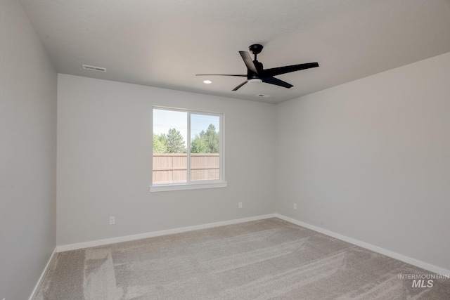 empty room featuring light colored carpet and ceiling fan