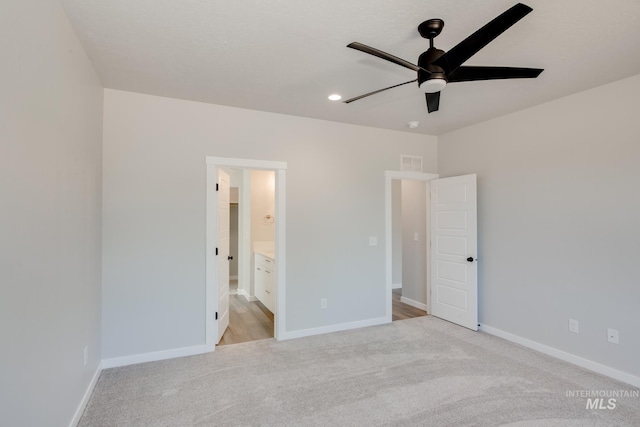 unfurnished bedroom with connected bathroom, light colored carpet, and ceiling fan