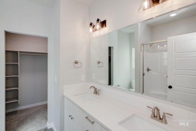 bathroom featuring vanity, an enclosed shower, and toilet