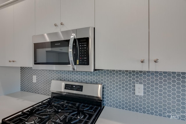 kitchen featuring white cabinets, stainless steel appliances, and tasteful backsplash