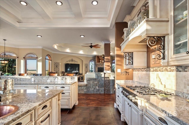 9105 W Mcmillan, Nampa, ID 83687 - kitchen with a ceiling fan, a fireplace, cream cabinetry, glass insert cabinets, and a tray ceiling