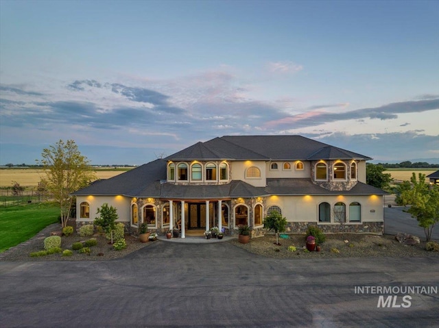 9105 W Mcmillan, Nampa, ID 83687 - view of front of property with stone siding, a porch, asphalt driveway, and stucco siding