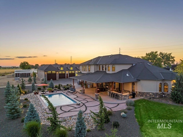 9105 W Mcmillan, Nampa, ID 83687 - rear view of property featuring a patio, stucco siding, stone siding, and an outdoor pool