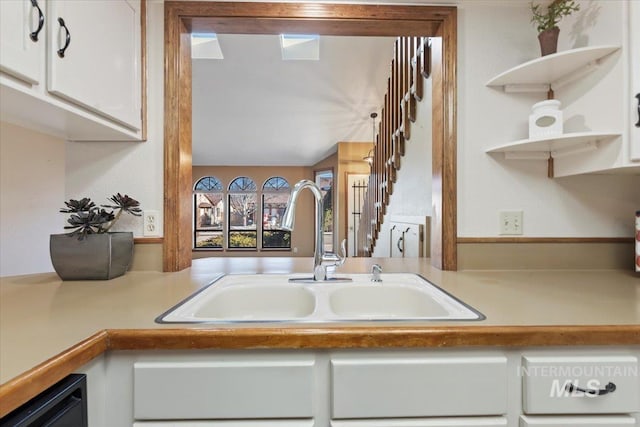 kitchen featuring dishwasher, sink, and white cabinetry