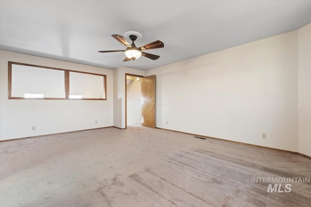 carpeted spare room featuring ceiling fan