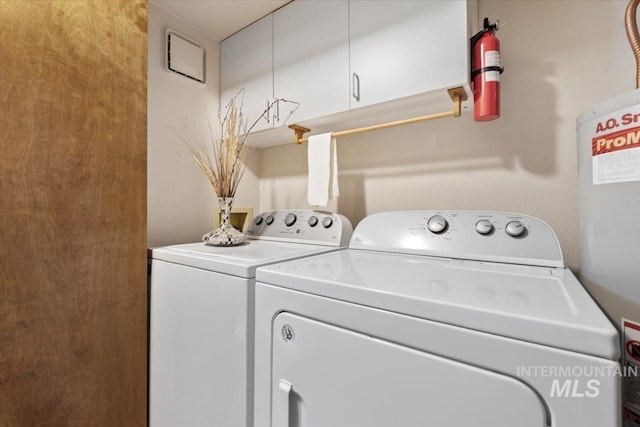 clothes washing area featuring cabinets and washer and dryer