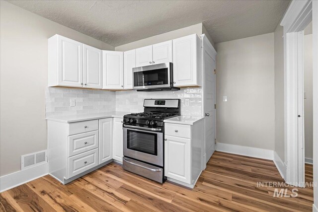 803 4th St S, Nampa, ID 83651 - kitchen with white cabinets, visible vents, light countertops, stainless steel appliances, and baseboards