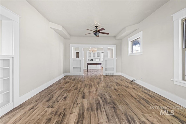 803 4th St S, Nampa, ID 83651 - unfurnished living room with visible vents, baseboards, wood finished floors, and ceiling fan with notable chandelier