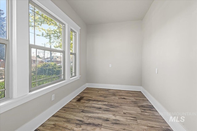 803 4th St S, Nampa, ID 83651 - spare room featuring dark wood-type flooring, baseboards, and plenty of natural light