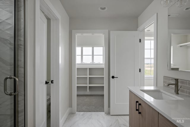 bathroom featuring vanity, toilet, and an enclosed shower