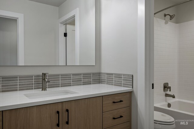 full bathroom with vanity, toilet, washtub / shower combination, and tasteful backsplash