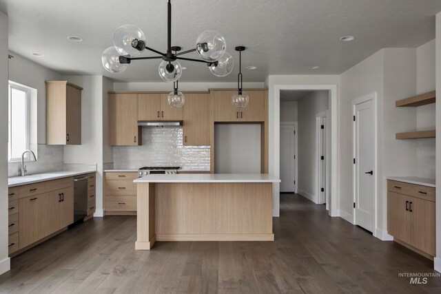 kitchen featuring pendant lighting, sink, hardwood / wood-style flooring, light brown cabinetry, and a kitchen island