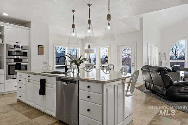 2873 W Wind Dr, Eagle, ID 83616 - kitchen featuring appliances with stainless steel finishes, white cabinetry, sink, hanging light fixtures, and a center island