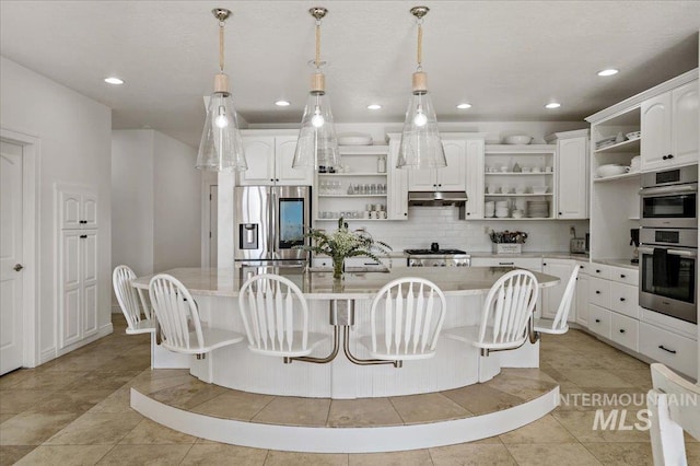 2873 W Wind Dr, Eagle, ID 83616 - kitchen with appliances with stainless steel finishes, decorative light fixtures, a center island with sink, and white cabinets