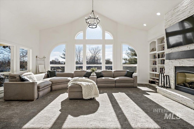 2873 W Wind Dr, Eagle, ID 83616 - carpeted living room featuring an inviting chandelier, built in shelves, a stone fireplace, and a high ceiling
