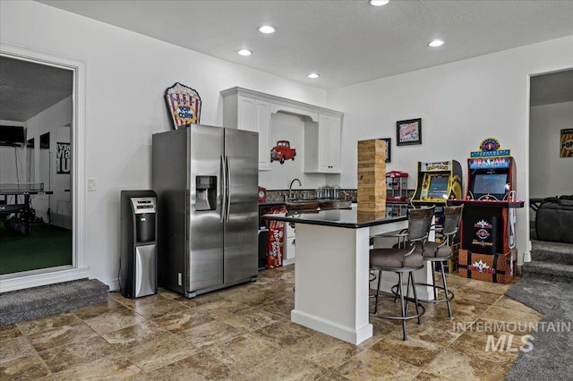 2873 W Wind Dr, Eagle, ID 83616 - kitchen with white cabinetry, a kitchen breakfast bar, and stainless steel fridge with ice dispenser
