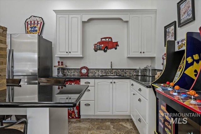 2873 W Wind Dr, Eagle, ID 83616 - kitchen featuring white cabinetry, sink, stainless steel fridge, and a kitchen bar