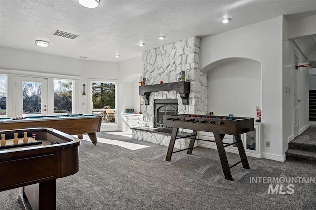 2873 W Wind Dr, Eagle, ID 83616 - rec room featuring a stone fireplace, french doors, a textured ceiling, and carpet
