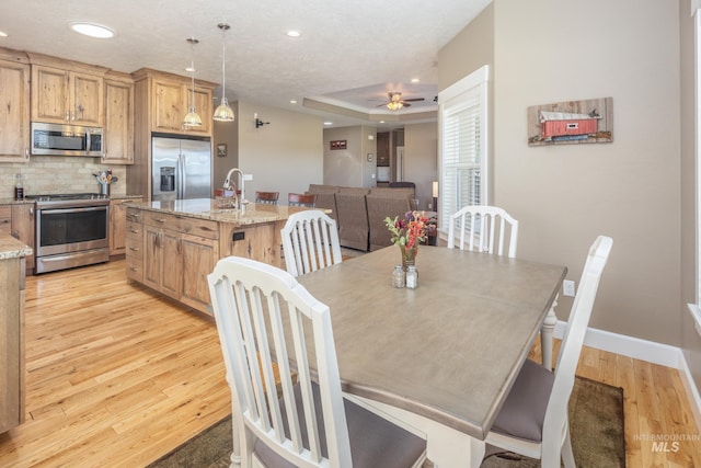 120 S Marko Ln, Kuna, ID 83634 - dining room featuring light wood-type flooring, a raised ceiling, a ceiling fan, baseboards, and recessed lighting
